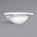 A close-up of an Elite Global Solutions white melamine bowl with curved edges.