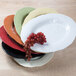 A stack of Elite Global Solutions Tuscany Black oval melamine platters with grapes on top.