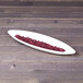 A white melamine gondola platter filled with red beans on a table.