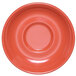A close-up of a coral Elite Global Solutions melamine coffee saucer with a circle in the center.