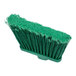A close-up of a Carlisle green broom head with green flagged bristles.