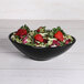 An Elite Global Solutions Moderne black melamine bowl filled with salad, strawberries, and lettuce.