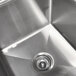 A close-up of the left drainboard on an Advance Tabco stainless steel commercial sink.