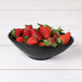 An Elite Global Solutions Moderne black melamine bowl filled with strawberries.