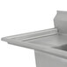 An Advance Tabco stainless steel commercial sink with two drainboards on a counter.