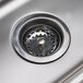 A close-up of the drain on an Advance Tabco stainless steel hand sink.