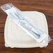 A plastic bag with a WNA Comet wrapped fork and knife on a plastic container.