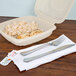 A WNA Comet plastic cutlery pack with a fork and a knife on a napkin.