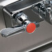 A close-up of a stainless steel sink with a gooseneck faucet and right side splash guard.