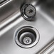 A stainless steel Advance Tabco hand sink with a drain and right side splash guard.