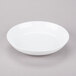 A 10 Strawberry Street white porcelain soup bowl on a gray surface.