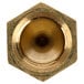 A close-up of a hexagon shaped brass nut with a threaded hole.