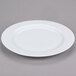 A 10 Strawberry Street classic white porcelain charger plate with a rim on a gray surface.