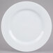 A white 10 Strawberry Street porcelain charger plate with a circular edge on a gray background.