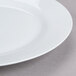 A close-up of a 10 Strawberry Street Royal White porcelain charger plate with a white rim.