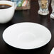 A white porcelain cup and saucer on a white plate.