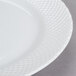 A close up of a 10 Strawberry Street White Wicker porcelain charger plate with a white background.