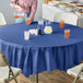 A table with a navy blue OctyRound tablecloth and glasses of yellow and orange liquid.