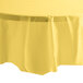 A mimosa yellow plastic round tablecloth with a white background.
