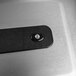 A black rectangular stainless steel object with a black round button.