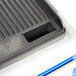 A close up of a black cast iron grill with white and blue Globe GPG14D cover.