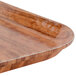 A close up of a trapezoid-shaped Java Teak fiberglass tray with a wooden handle.