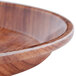 A close up of a Cambro java teak fiberglass tray with a wooden bowl on a table.