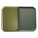 Two olive green Cambro trays, one empty and one full, on a counter.