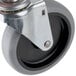 A close-up of a black Rubbermaid and Carlisle swivel stem caster wheel with a metal plate on top.
