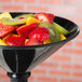 A black bowl filled with fruit on a table.
