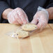 A person in gloves putting a cookie in an LK Packaging plastic sandwich bag.