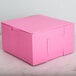 A pink 7" x 7" x 4" cake box on a marble surface.