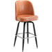 A caramel brown vinyl bar stool with a swivel bucket seat and black legs.