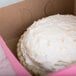 A pie in a 9" x 9" pink bakery box with a white top.