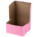 A pink bakery box with a brown lid.