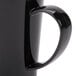 A close up of a black Carlisle Tritan mug with a handle.