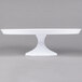A Fineline white pedestal cake stand on a white table.