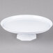 A Fineline white pedestal cake stand with a white plate on a pedestal.