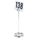 An American Metalcraft chrome swirl base table card holder with a number on it.