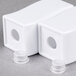 Two white plastic cubes with holes in them.
