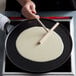 A person using a Chasseur cast iron crepe pan to make pancakes.