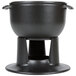 A black Chasseur enameled cast iron fondue pot on a stand.