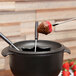 A Chasseur enameled cast iron fondue pot with chocolate and strawberries.