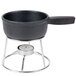 An American Metalcraft black cast iron fondue pot on a stand with a candle.