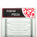 A Nemco countertop pizza merchandiser with a sign on a rack filled with pizza.