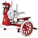 A red and white Omcan manual meat slicer with flower wheel.