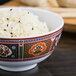 A Thunder Group Peacock melamine rice bowl filled with rice and black sesame seeds with chopsticks.