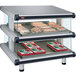 A Hatco countertop display case with food on slanted glass shelves.
