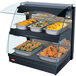 A Hatco countertop curved merchandising warmer with trays of food inside.