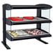 A black Hatco countertop heated display case with food on shelves.
